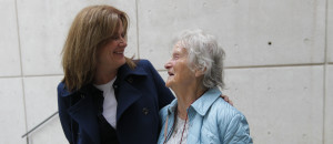 An older and younger woman smiling at each other