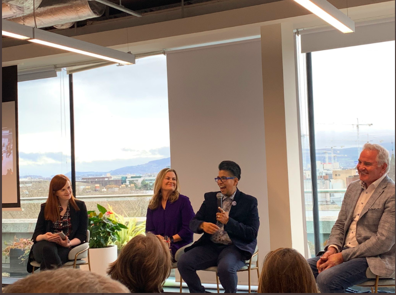 People on a panel laughing